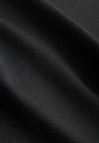 Czarny materiał o gładkiej, lekko teksturowanej powierzchni, z delikatnym prążkowaniem. Tkanina jest nieprzezroczysta i ma matowe wykończenie.