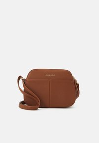 Brun faux læder crossbody taske med en glat overflade, rektangulær form, lynlåslynlås i toppen og logo detaljer i guldtoner. Justerbar rem.