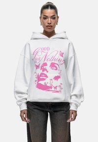 Witte hoodie met een oversized pasvorm, featuring een roze grafische print van een gezicht omringd door vlinders en bloemelementen.