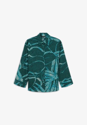 Camicia teal con motivi astratti blu, colletto ampio, chiusura a bottoni frontale e maniche lunghe. Presenta dettagli ritagliati per aggiungere texture.