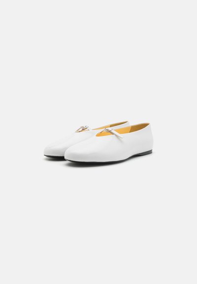 White leather ballet flats with a rounded toe, featuring a slim bow detail on the upper and a contrasting yellow insole. Black outsole.