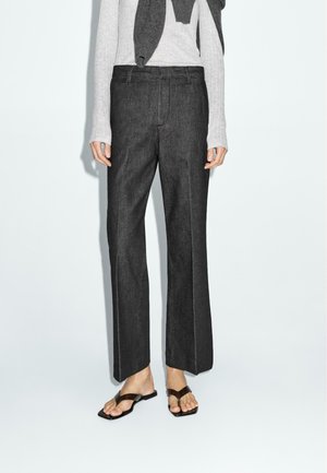 Dark grey straight-leg pants made of a soft fabric, featuring front crease lines and a mid-rise waistband, paired with a light grey sweater.