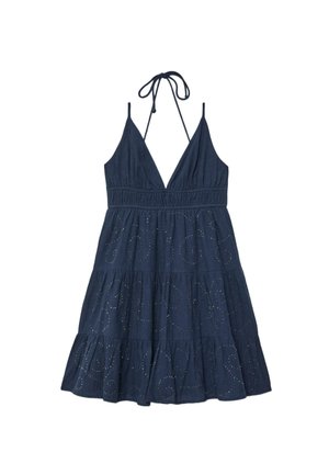 Robe sans manches bleu marine avec col halter décolleté en V profond, taille froncée, jupe à volants et broderie à œillets en spirale subtile sur toute la robe.