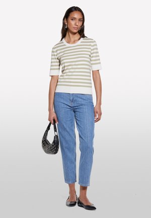 Striped short-sleeve sweater in light olive and cream, paired with blue high-waisted jeans, black flats, and a patterned black handbag.