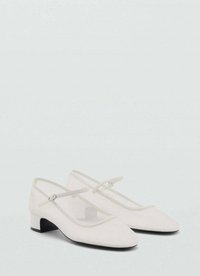 Des chaussures de ballet blanches présentent un panneau latéral en mesh, un bout arrondi et un petit talon noir. Une sangle ajustable est présente sur le cou-de-pied.