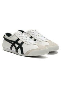 Hvide lædersneakers med sorte striber, beige ruskindsto, rund tåform, hvide snørebånd og struktureret gummisål.