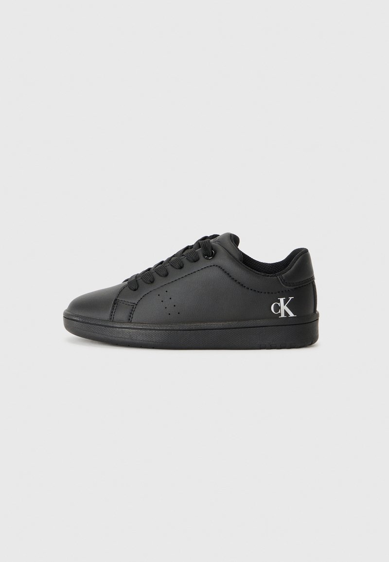 Svart lädersneaker med rund tå, perforerad detaljering och fyra snörhål. Har en svart gummisula och en silverfärgad logotyp. 