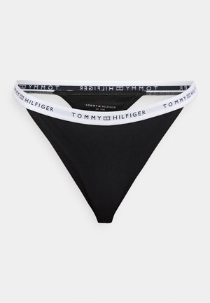 Črne tangice iz mehke tkanine z belim elastičnim pasom v kontrastni barvi. Pas s ponavljajočim napisom blagovne znamke.