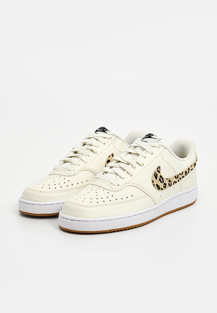 Weiße Leder Sneakers mit Perforationen, schwarzem und Leopardenmuster-Swoosh, weißer Zwischensohle und brauner Gummisohle. Mit robusten Schnürsenkeln.
