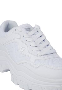 Sneaker bianca con allacciatura, caratterizzata da una tomaia in pelle texturizzata, linguetta imbottita e una suola in gomma spessa e rigata con un delicato logo.