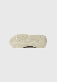 Shoe sole with a textured rubber design, featuring curved grooves and a light cream color. "HUGO" logo embossed on the heel area.