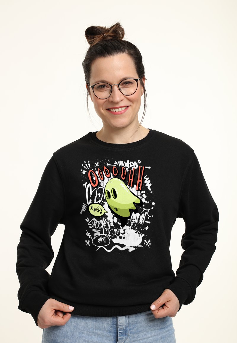 Felpa nera con una grafica di un fantasma in stile cartoon in verde, con testo rosso e spruzzi bianchi. Il design include espressioni giocose.