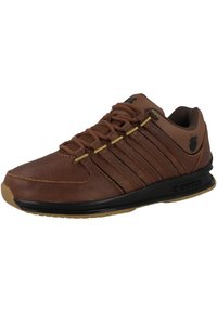 Hnědá kožená sportovní bota s černými akcenty, s texturovaným povrchem, šesti otvory na šňůrky a gumovou podrážkou pro lepší přilnavost.