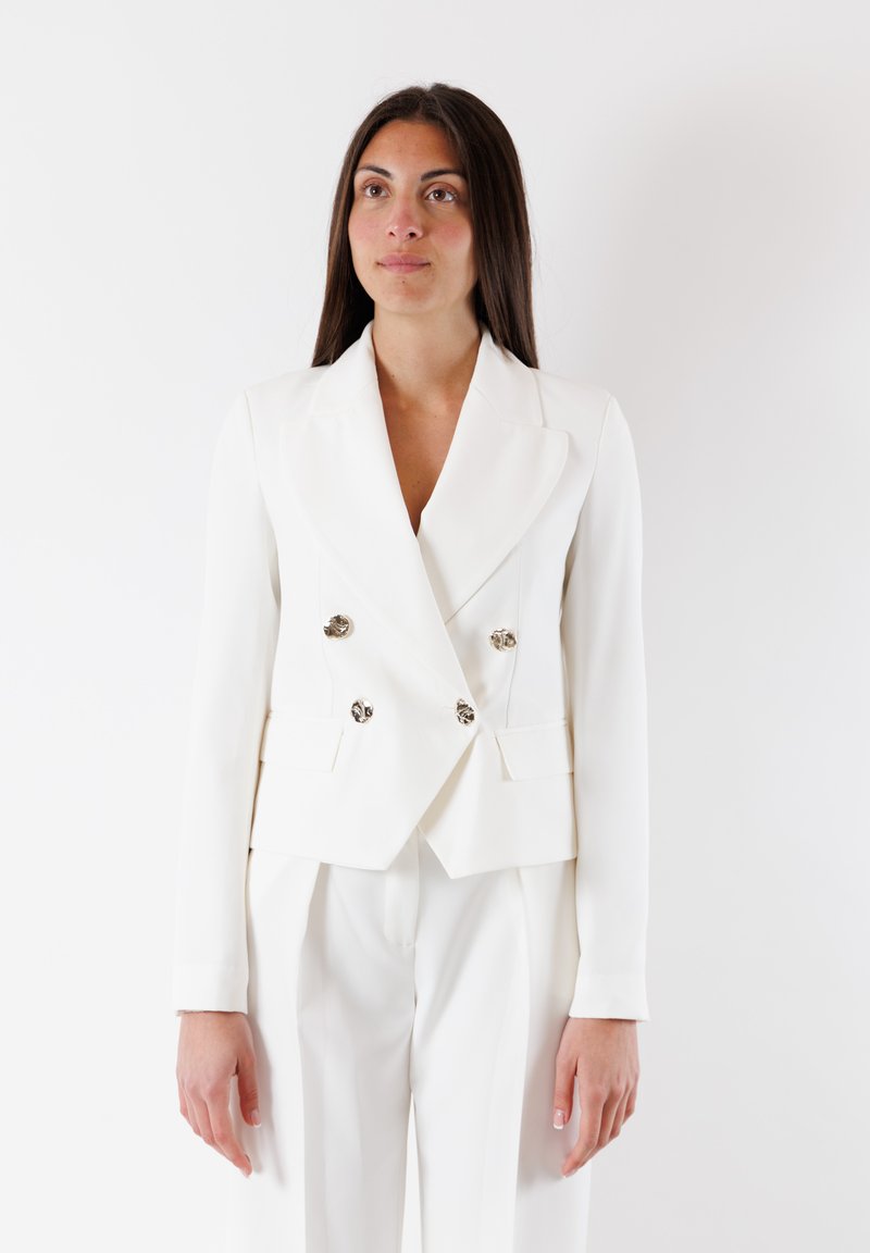 Blazer bianco doppiopetto con botttoni argentati lucidi, vestibilità sartoriale, rever a scollo e due tasche laterali, realizzato in tessuto liscio.