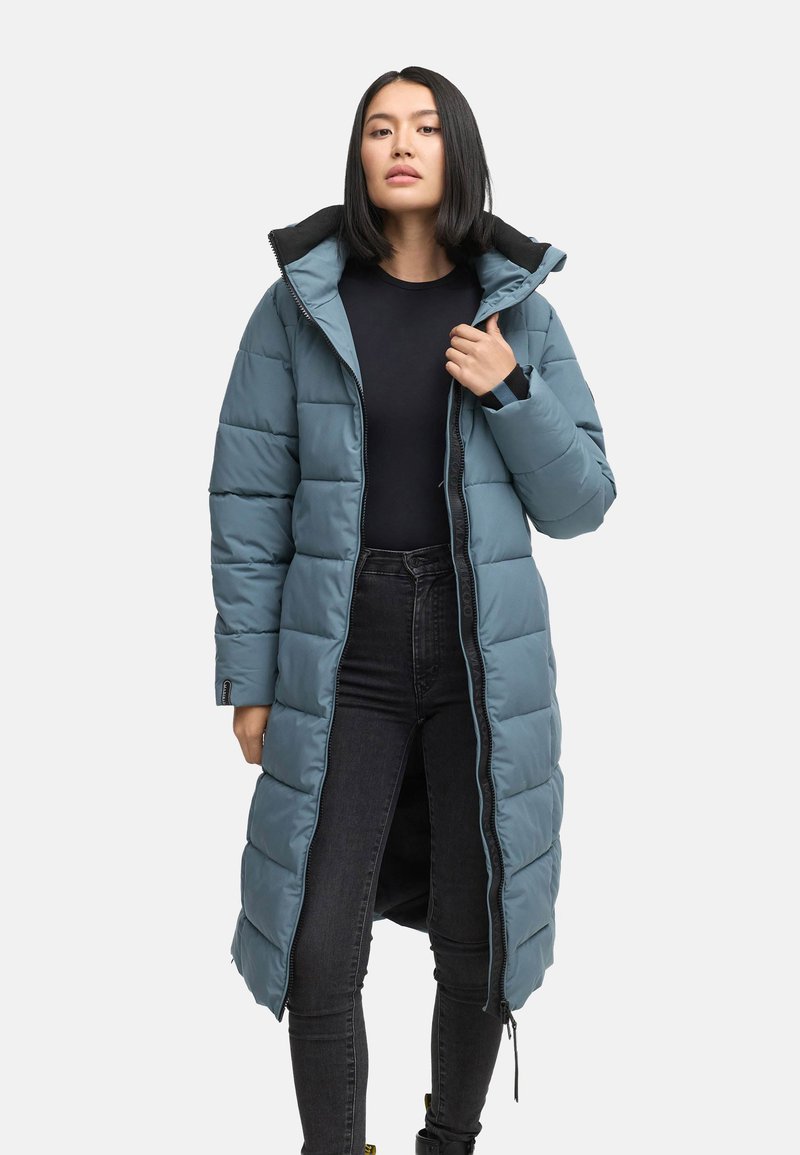 Dug nad rahle plava puffer jakna s kapuljačom, s patentnim zatvaračem, crnim detaljima i bočnim džepovima s patentnim zatvaračem. Sjajna, kviltana tekstura.