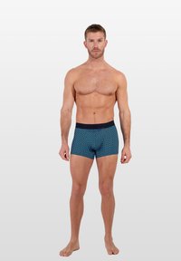 Boxers bleus à motifs avec une ceinture marine, fabriqués en tissu extensible, présentant un design géométrique et une coupe ajustée pour le confort.