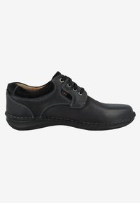 Scarpa in pelle nera con lacci, finitura testurizzata, punta tondeggiante, cuciture a contrasto e suola in gomma per stabilità.