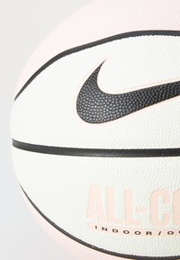 Nike basketball with a textured white surface, pink accents, and a black swoosh logo. Features a black seam and "ALL-COL" branding.