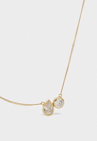 Zlatna lančić sa dvije prozirne gemstone: u obliku suze i okruglom obliku, oboje uokvireni zlatnim metalnim akcentima.