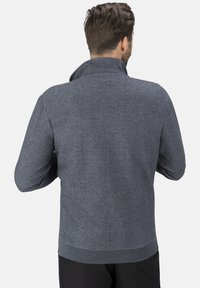 Grauer Fleece-Jacke mit hohem Kragen und geripptem Saum. Glatte Textur und lässiges Design, Rückansicht ohne Details von der Vorderseite.