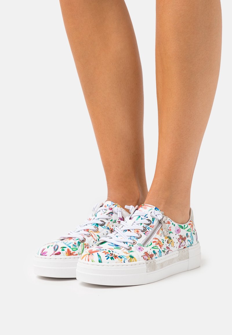 Sneaker bianche con motivo floreale, dotate di linguetta imbottita, chiusura con lacci e zip laterale; suola in gomma testurizzata per presa e comfort.