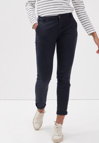 Pantalones azul marino de corte slim con puños doblados, hechos de una mezcla de algodón. Cuentan con dos bolsillos laterales y cierre frontal con botones.