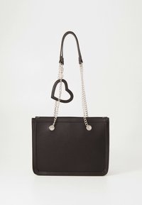 Sac à main rectangulaire noir avec des anses en chaîne argentée et un charm en forme de cœur noir attaché à une anse, sur fond blanc.