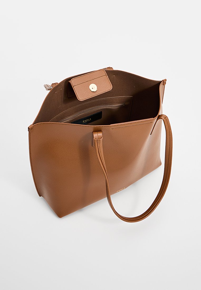 Brązowa skórzana torba typu tote z teksturowaną powierzchnią, otwartym wnętrzem i zapięciem na klapkę z guzikiem. Posiada długie rączki i przestronną wnętrze.