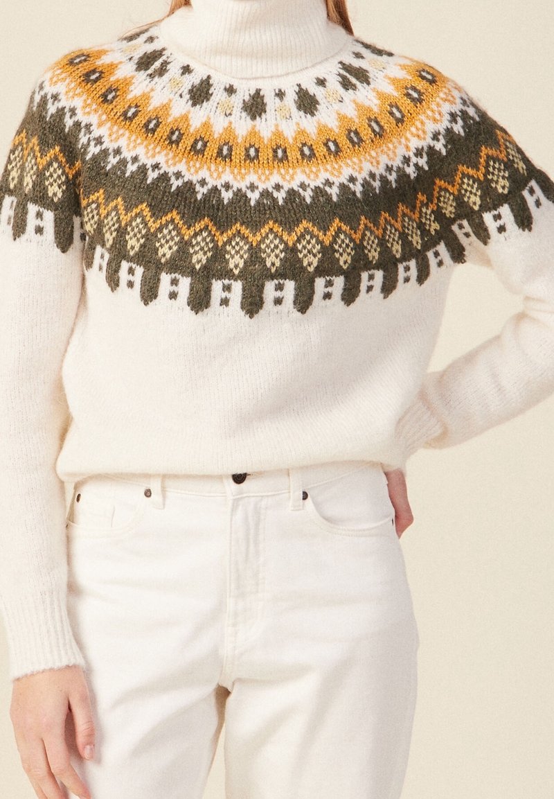 Pletený svetr v krémové barvě s vzorovaným sedlem, zdobený oranžovými, zelenými a tmavě žlutými akcenty. Vysoký límec a žebrované manžety.
