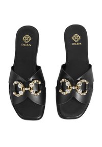 Sandales noires à semelle glissante avec une finition en cuir lisse, dotées d'un accent en chaîne dorée ornée de pierres transparentes et d'un logo sur la semelle intérieure.