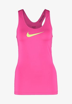 Nainen seisoo, pukeutuneena vaaleanpunaiseen Nike-tankkitoppiin, neonkeltaisiin Nike-shortseihin ja neonkeltaisiin sekä valkoisiin Nike-juoksukenkiin.
