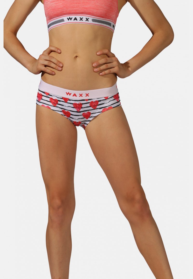 Sous-vêtements féminins avec une base blanche ornée de rayures noires et de cœurs rouges, soulignés par une ceinture blanche portant le nom de la marque "WAXX" en rouge.