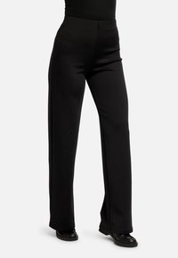 Laiade mustad püksid, mis on valmistatud siledast ja elastset kangast, varustatud kõrge vöökohaga ja peene esiseelme detailiga.