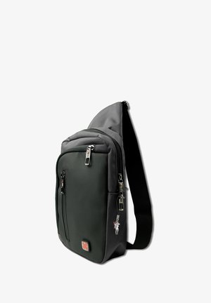 Compact zwarte schoudertas met meerdere ritscompartimenten, verstelbare schouderband en een rood kruislogo op het voorvak.