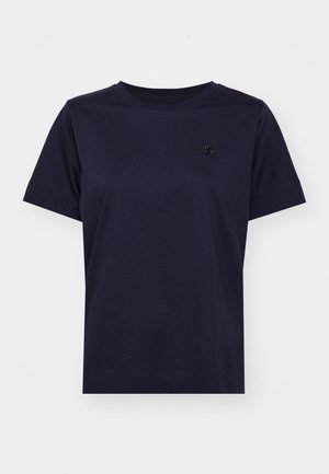 Tamsiai mėlynas medvilninis marškinėliai su trumpomis rankovėmis, apvaliu iškirpimu ir mažu tekstūriniu logotipu ant krūtinės. Minimalistinis dizainas ir glotni tekstūra.