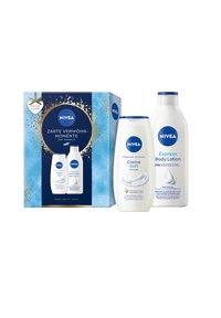 Nivea Creme Soft Duschcreme und Express Körperlotion mit blau-weißer Verpackung neben einer blauen Geschenkbox mit goldenen Akzenten.