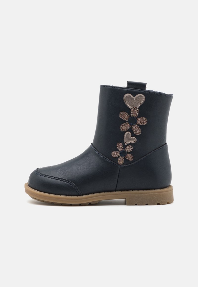 Bottine noire pour enfants avec semelle beige, décorée de fleurs pailletées et de patchs en forme de cœur sur le côté extérieur.