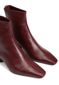 Burgundowe skórzane botki za kostkę z wysmuklonym noskiem oraz eleganckim wzornictwem, wyposażone w zamek błyskawiczny z boku oraz gładką, błyszczącą teksturę.