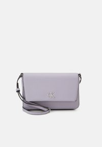 Fialová kabelka přes rameno z umělé kůže se zavíráním na klopu, stříbrným logem a nastavitelným popruhem. Hladká textura a strukturovaný tvar.