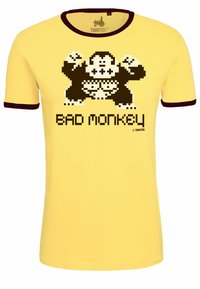Yellow cotton t-shirt with a crew neck and maroon trim, featuring a pixelated monkey graphic and the text "BAD MONKEY" in black.