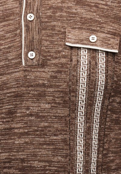 Καφέ πλεκτό πουκάμισο με κάθετες λευκές ριγέ διακοσμήσεις, τσέπη στο στήθος με κουμπιά και δύο λευκά κουμπιά στη στήλη κουμπιών.