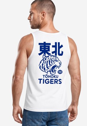 Mann trägt weißes ärmelloses Shirt mit blauem brüllendem Tiger und Text "Tōhoku Tigers" sowie japanischen Schriftzeichen auf dem Rücken.