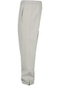 Helle graue Sweatpants mit einem Kordelzug-Bund, Seitentaschen und Reißverschluss-Bündchen. Aus weichem Stoff mit sauberen Nähdetails gefertigt.