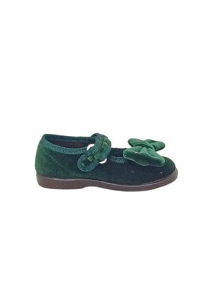 Scarpa da bambino in velluto verde con cinturino e fiocco decorativo sopra, suola piatta marrone.
