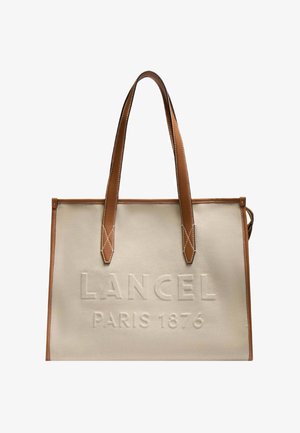 Borsa tote in tela beige con manici e rifiniture in pelle marrone, con la scritta "LANCEL PARIS 1876" in rilievo sulla parte anteriore.
