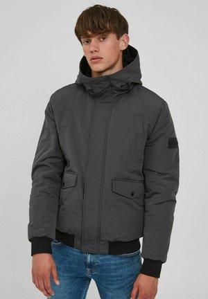 Grau der Kapuzenjacke mit Reißverschluss, zwei Fronttaschen, elastischen Bündchen und geripptem Saum. Glatte Textur und strapazierfähiger Stoff.