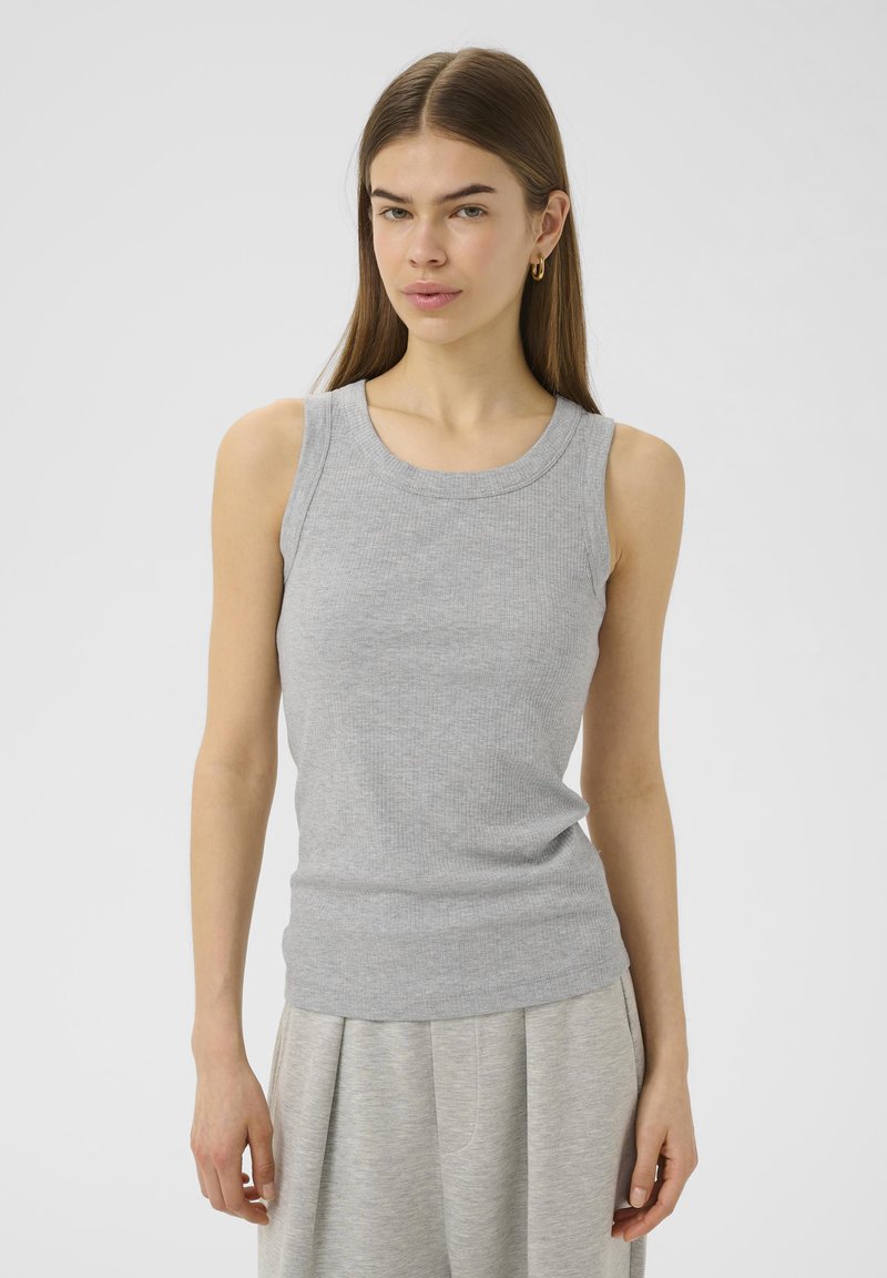 Hallide ribidega must tank top ümarate kaeluste ja ilma varrukatest, koos hallide pükstega. Kangas näeb välja pehme, painduv ja igapäevane.