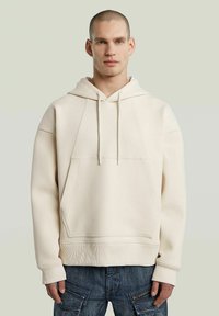 Lichtbeige hoodie van zacht materiaal, met een grote voorzak, verstelbare trekkoordcapuchon en ribgebreide manchetten en zoom.