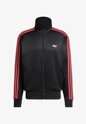 Zwarte trainingsjack met een hoge kraag, voorzien van verticale ribbels, rode gestreepte accenten op de mouwen en een klein wit logo op de borst.
