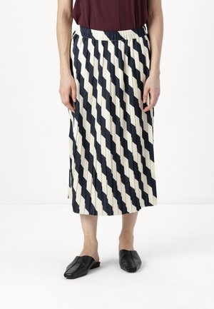 Skråstripete skjørt i marineblått og kremfarget, midt-lengde med elastisk midje. Kombinert med svarte slip-on sko. Glatt stofftekstur.